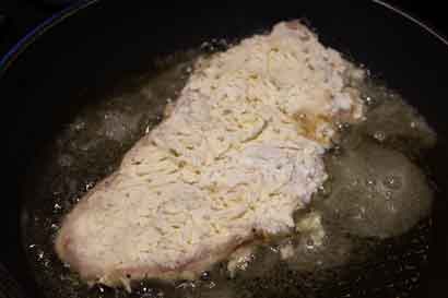 coated chicken breast frying